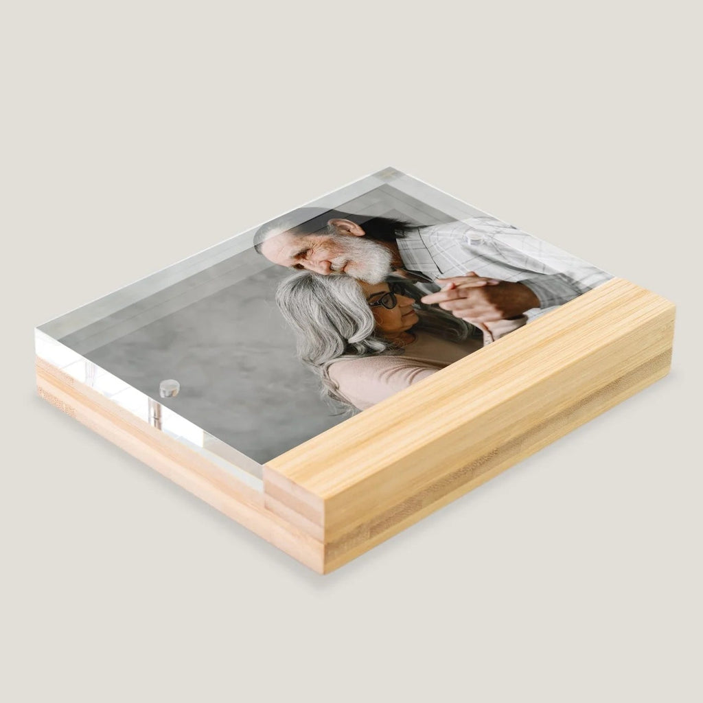Acrylic photo block with wooden base displaying a family photo on a light gray background