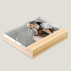 Acrylic photo block with wooden base displaying a family photo on a light gray background