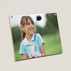Photo Young girl holding a golf club in a bamboo frame