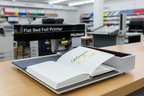 Flat Bed Foil Printer with open book and gold foil text
