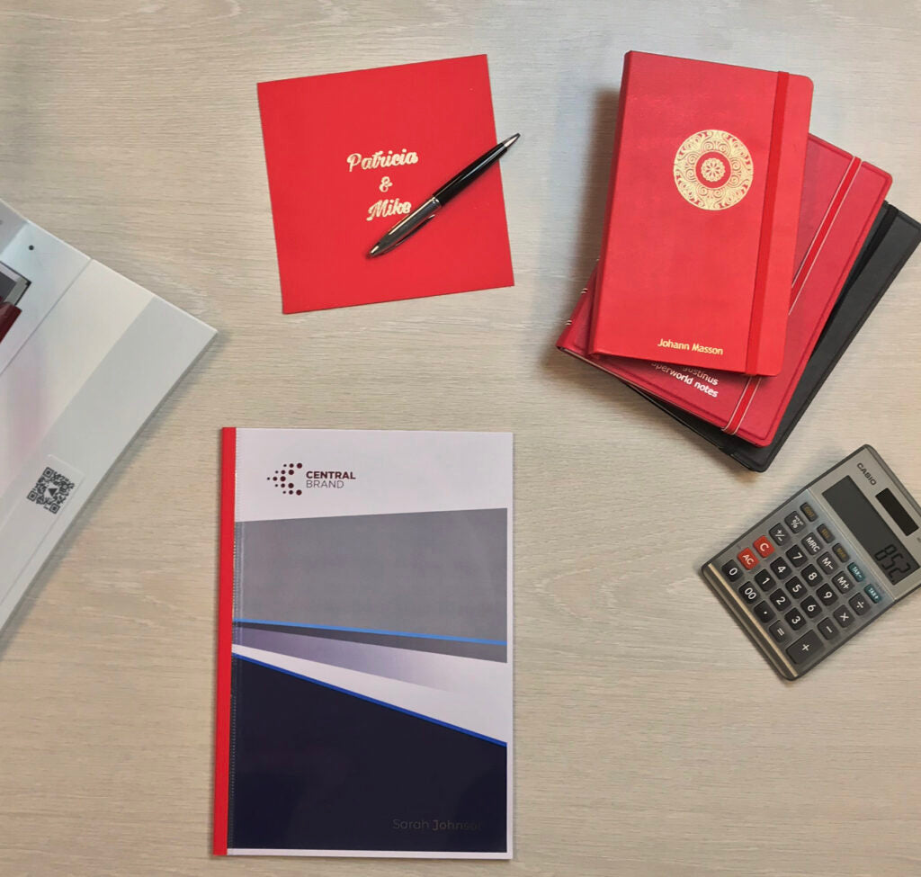 Red notebooks, with Gold foil and  a Central University of Technology thermal bound cover.